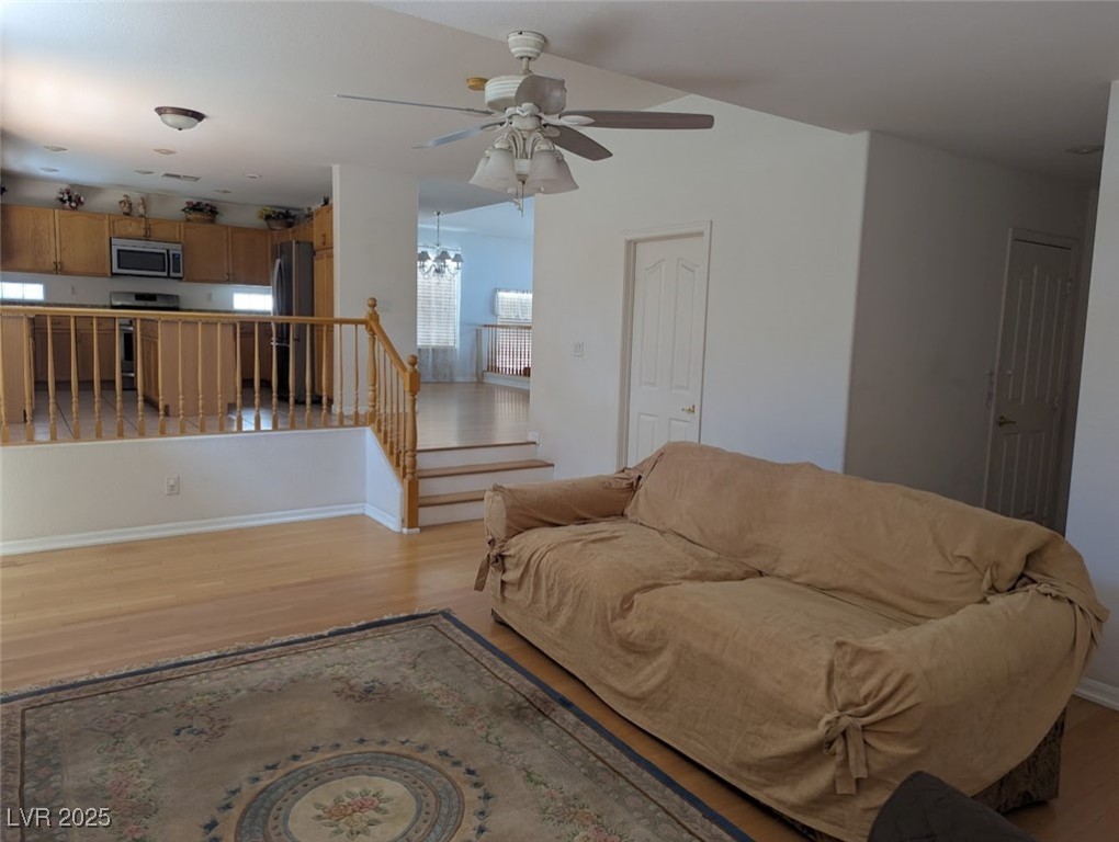 4777 Crakow Court Las Vegas, NV 89147 - Photo 43 of 49 Living room featuring light wood-style flooring, a chandelier, and a ceiling fan