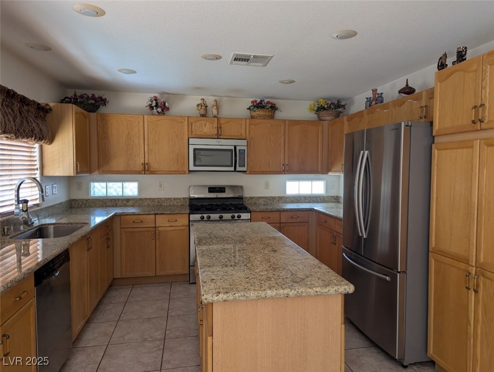 4777 Crakow Court Las Vegas, NV 89147 - Photo 47 of 49 Kitchen featuring stainless steel appliances, light tile patterned floors, and light stone counters