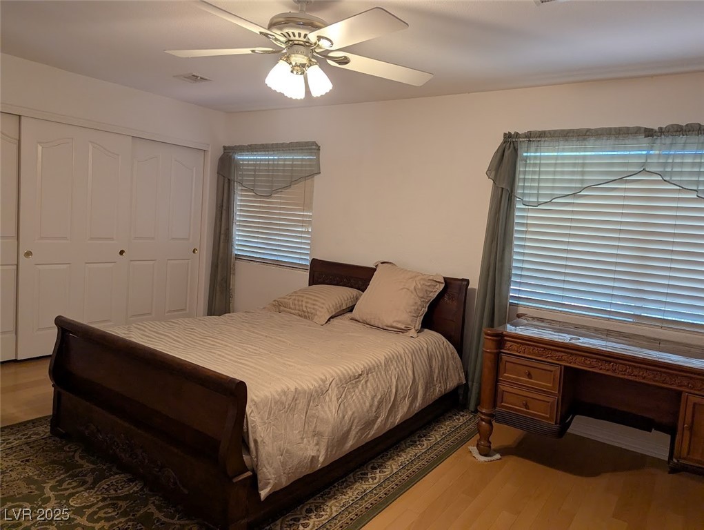 4777 Crakow Court Las Vegas, NV 89147 - Photo 8 of 49 Bedroom featuring wood finished floors, a ceiling fan, a closet, and multiple windows