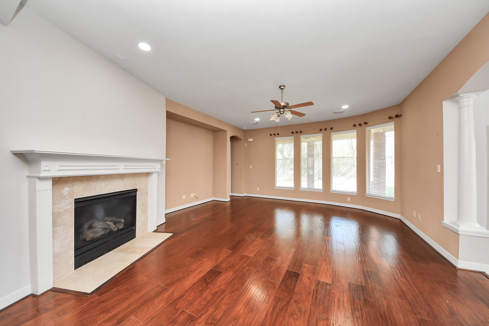 17618 Raven Canyon Lane Houston, TX 77095 - Photo 12 of 45 Spacious living room featuring a cozy fireplace, high ceilings, and beautiful hardwood floors. Ideal for relaxation and family gatherings.