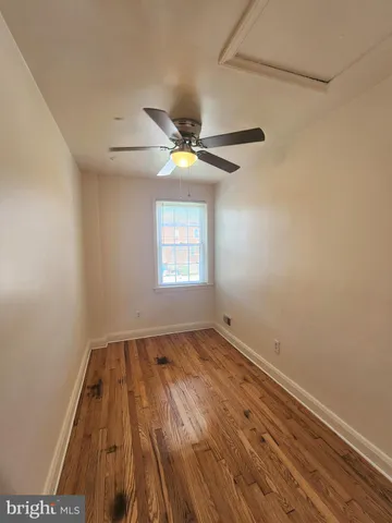 an empty room with a window and a ceiling fan