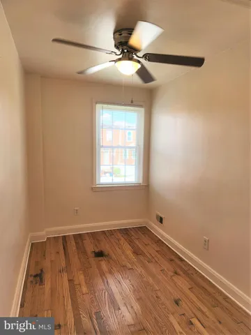 a view of room with a ceiling fan and wooden floor