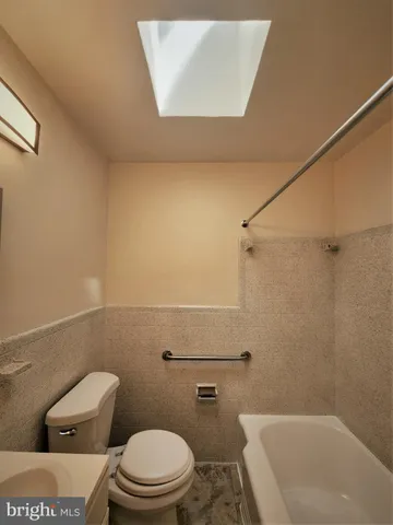 a white toilet sitting next to a bath tub