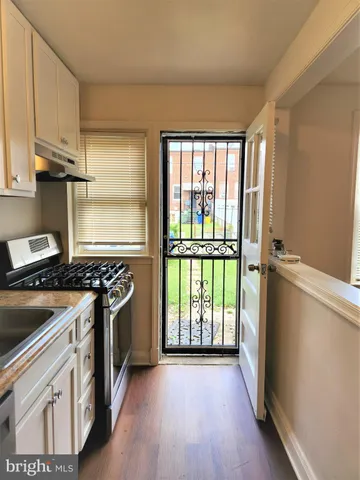 a kitchen with wooden floor and a stove top oven