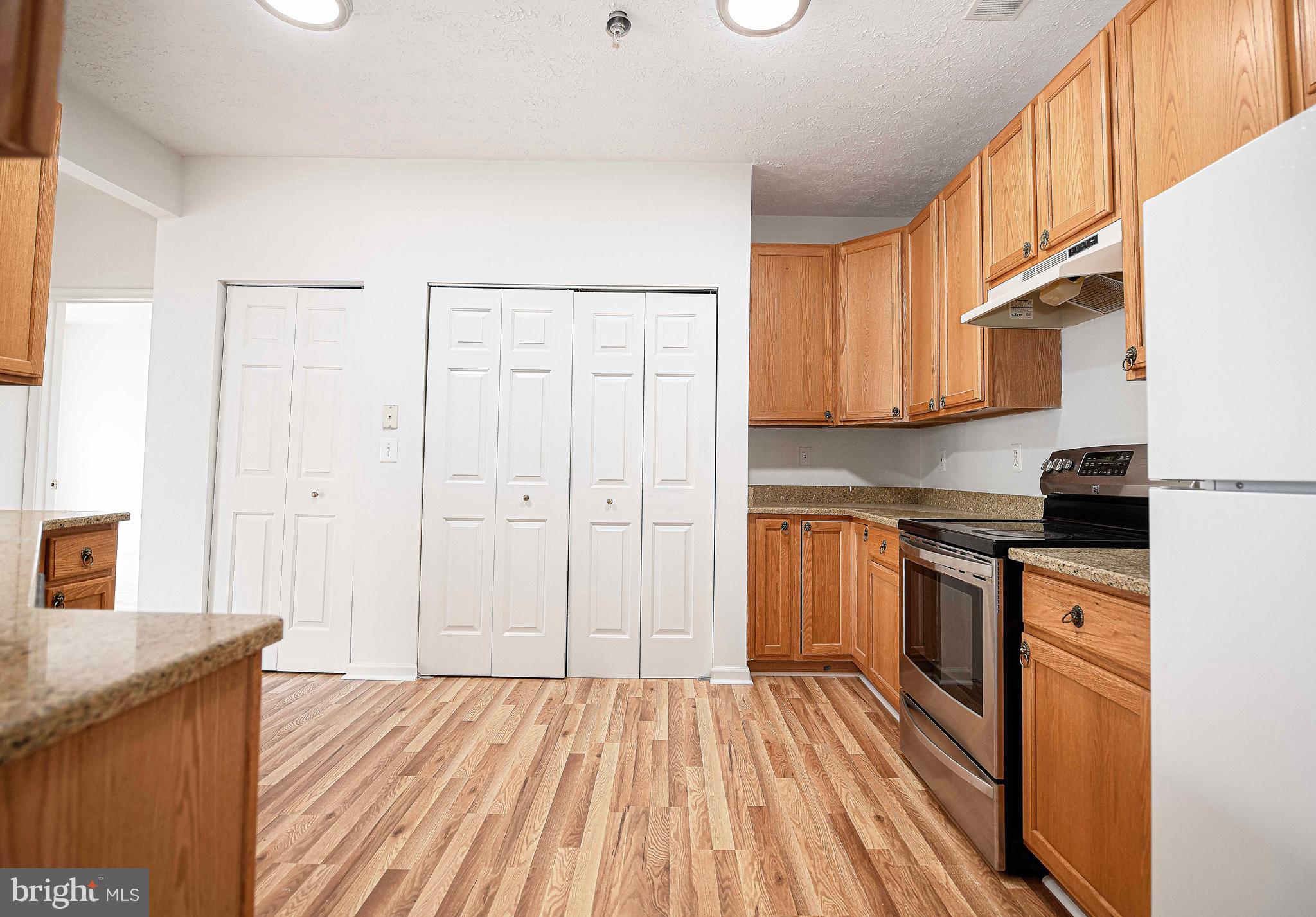 9606 Haven Farm Road, Unit E Perry Hall, MD 21128 - Photo 22 of 33 a kitchen with stainless steel appliances granite countertop a refrigerator a stove and a wooden floors