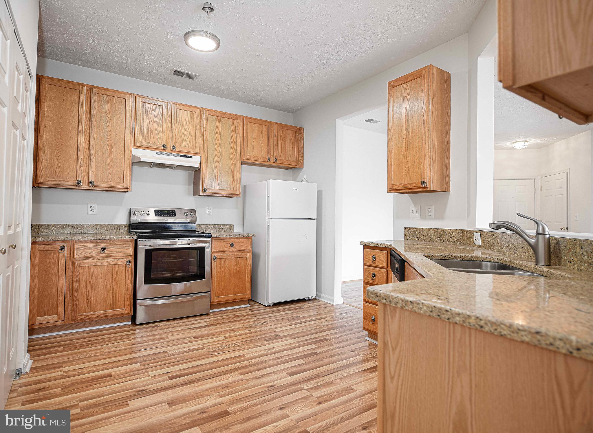 9606 Haven Farm Road, Unit E Perry Hall, MD 21128 - Photo 24 of 33 a kitchen with granite countertop a refrigerator stove and sink
