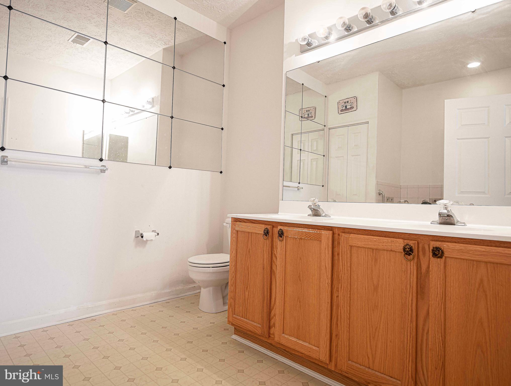 9606 Haven Farm Road, Unit E Perry Hall, MD 21128 - Photo 28 of 33 a bathroom with a granite countertop sink a toilet and mirror