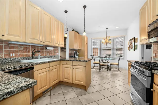 a kitchen with stainless steel appliances granite countertop a stove a sink and a refrigerator