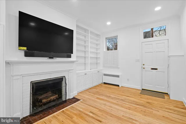 a living room with flat screen tv and a fireplace
