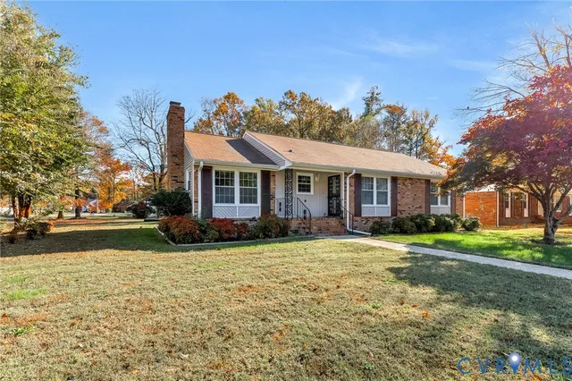 a front view of a house with a yard and trees