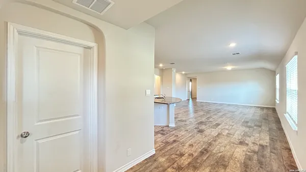 a view of a hallway to a room with a window