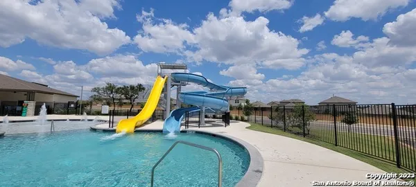 a view of a swimming pool with a bench and fire pit