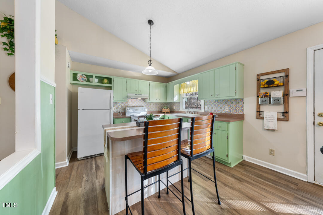 1008 Torredge Road Durham, NC 27712 - Photo 15 of 31 a kitchen with stainless steel appliances granite countertop a refrigerator a sink dishwasher a dining table and chairs with wooden floor