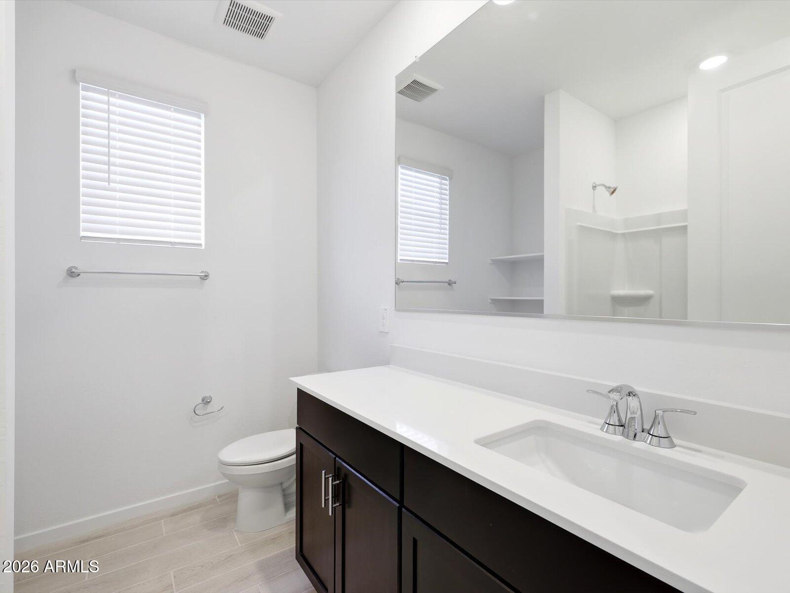 2392 Grenache Road San Tan Valley, AZ 85143 - Photo 6 of 67 a bathroom with a granite countertop sink toilet a mirror and a window