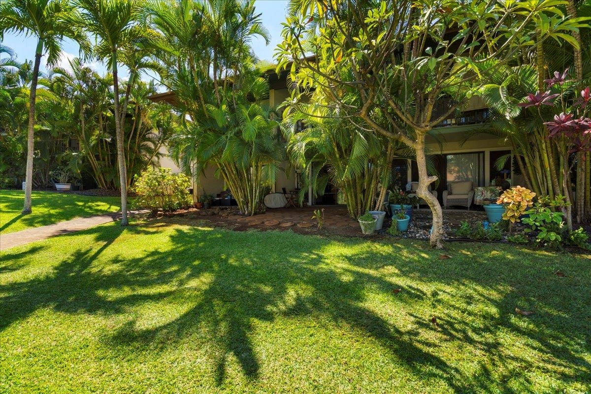 3788 Lower Honoapiilani Road, Unit A114 Lahaina, HI 96761 - Photo 15 of 18 a view of a backyard with table and chairs and potted plants and large trees