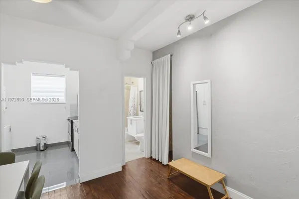 an empty room with wooden floor and a bathroom