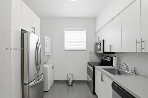 a kitchen with a refrigerator sink and cabinets