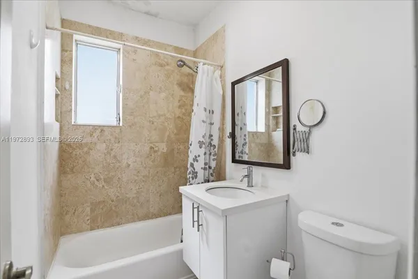 a bathroom with a granite countertop sink a toilet and shower