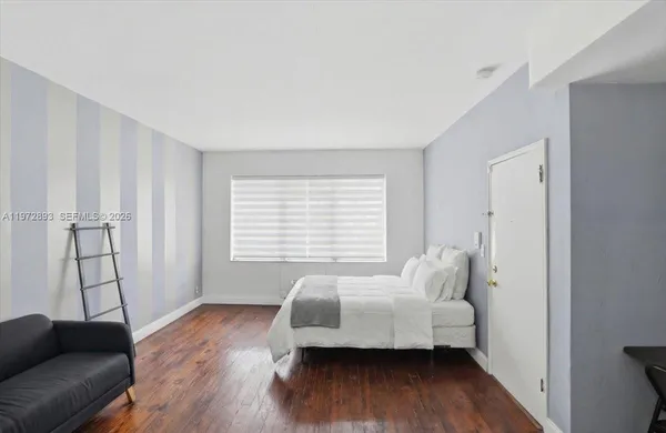 a bedroom with furniture and a wooden floor