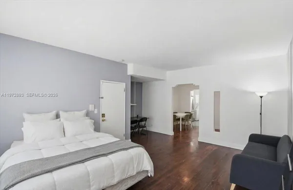 a spacious bedroom with a bed and wooden floor