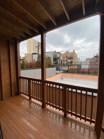 a view of a roof deck with wooden floor and outdoor seating