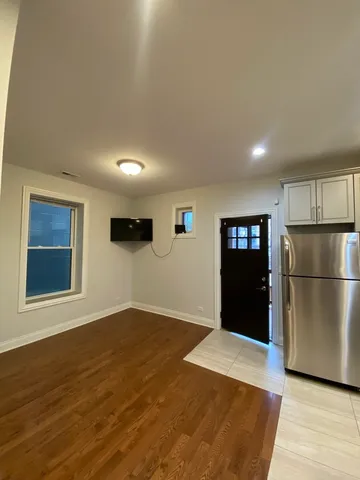 a view of a kitchen with wooden floor and electronic appliances