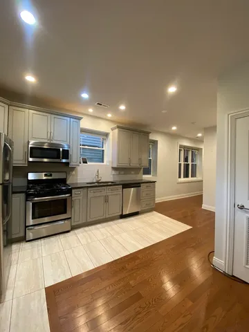 a kitchen with stainless steel appliances kitchen island granite countertop a stove and a sink