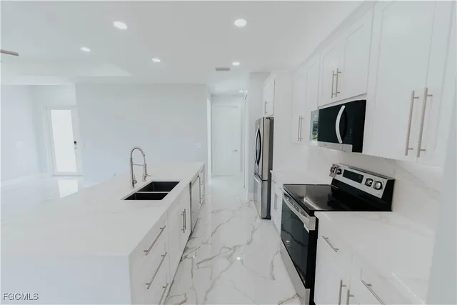 a kitchen with stainless steel appliances a microwave a sink a stove and refrigerator