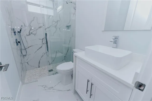 an empty room with a windows and chandelier fan