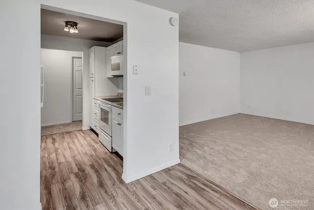 a view of a kitchen with wooden floor and electronic appliances