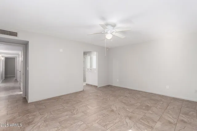 an empty room with a ceiling fan and a window