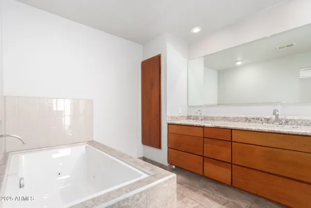a bathroom with a tub sink and mirror