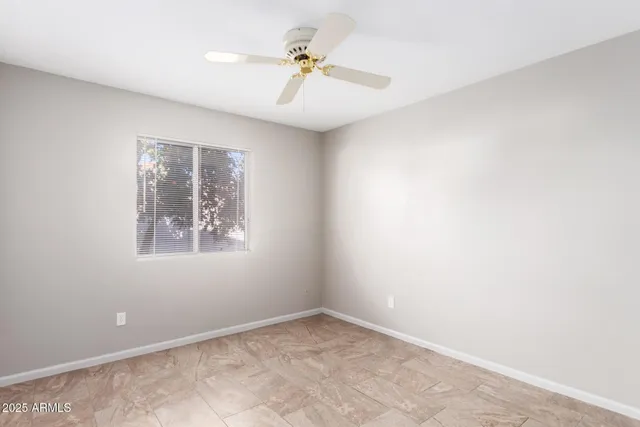 an empty room with a window and a fan