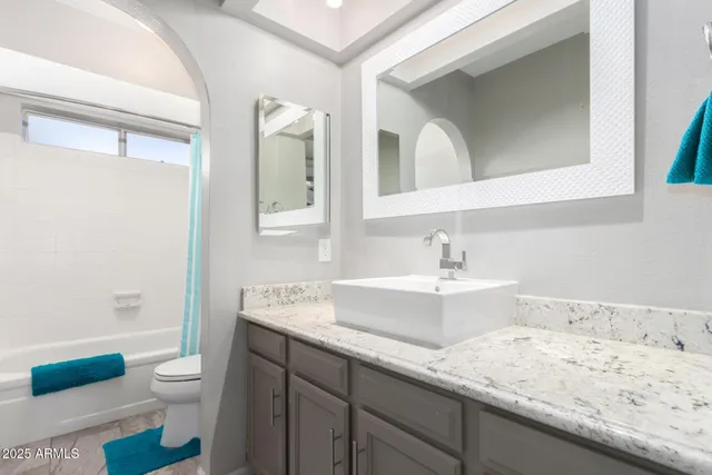 a bathroom with a granite countertop sink a toilet and a bathtub