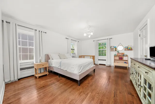 a spacious bedroom with a bed and a wooden floor