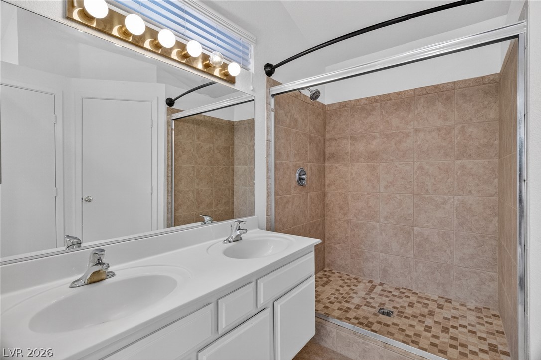3156 Terrace View Drive Laughlin, NV 89029 - Photo 34 of 94 Double vanity sinks and an inviting tile-lined shower create a functional bathroom.