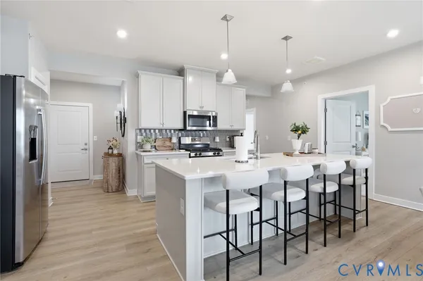 a kitchen with kitchen island granite countertop a sink a center island and stainless steel appliances