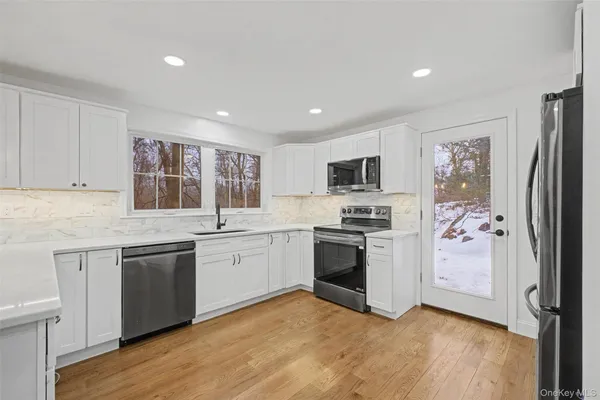a kitchen with granite countertop stainless steel appliances a sink and a refrigerator