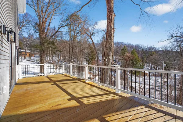 a view of balcony with wooden floor and fence