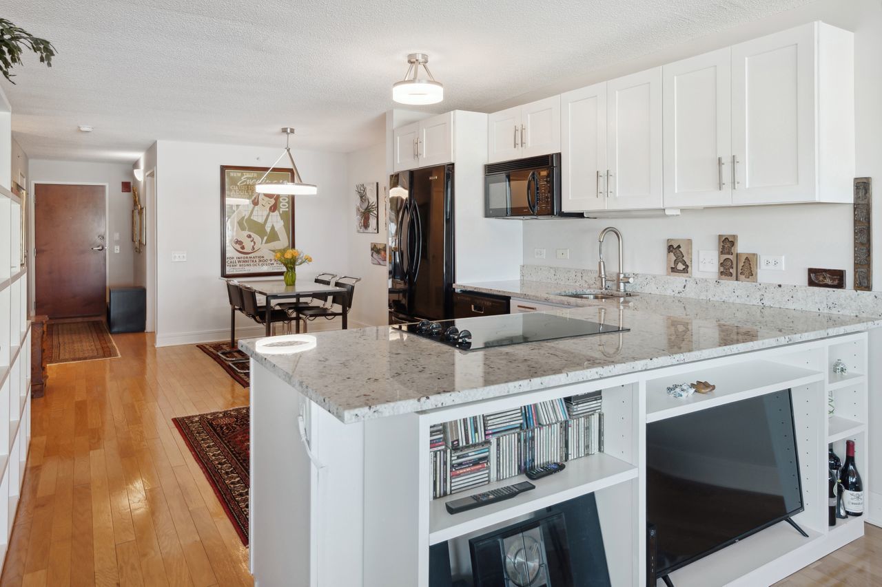 800 Elgin Road, Unit 1419 Evanston, IL 60201 - Photo 3 of 28 a kitchen with stainless steel appliances granite countertop a sink and a stove