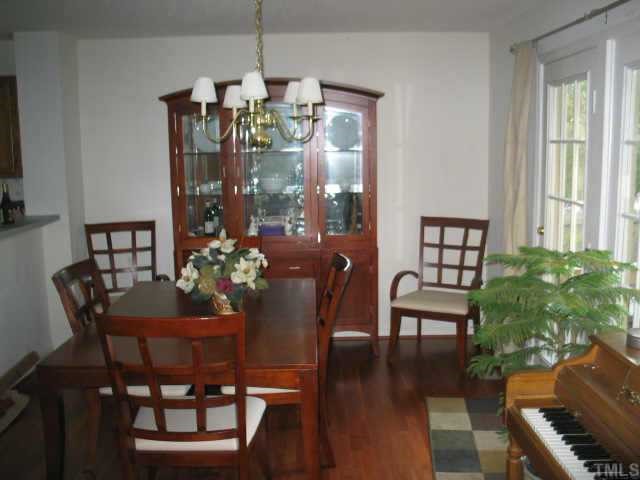 5409 Pennfine Drive Raleigh, NC 27610 - Photo 2 of 10 a dining room with furniture a chandelier and wooden floor