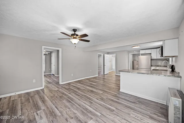 a view of empty room with wooden floor and window