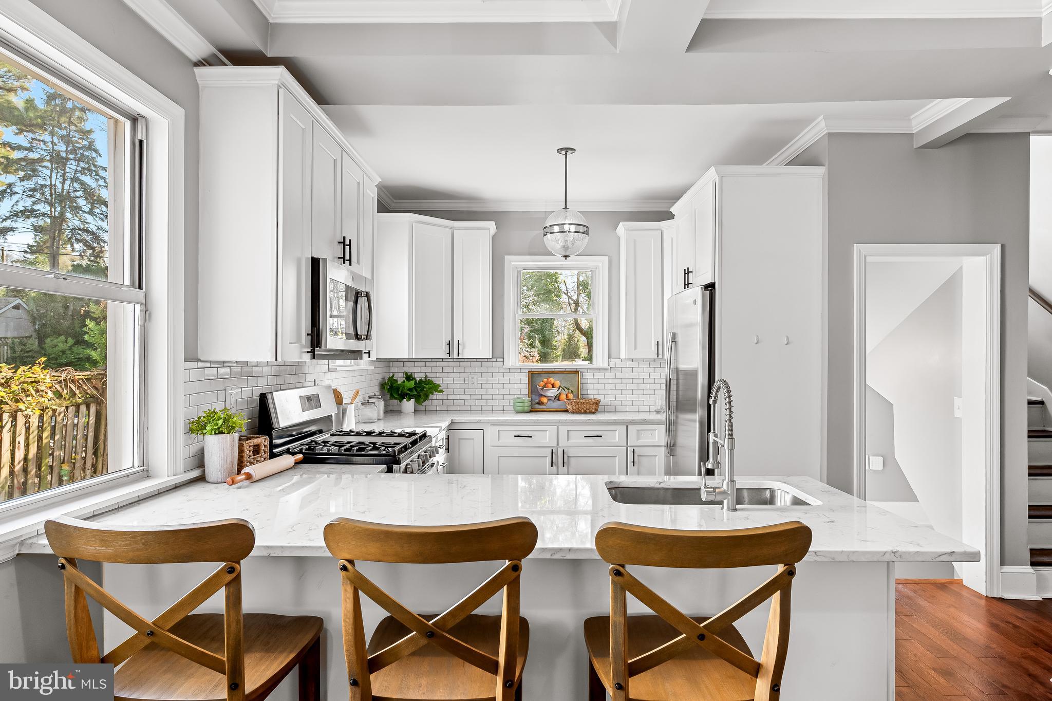 709 Cedarcroft Road Baltimore, MD 21212 - Photo 13 of 38 a kitchen with a dining table chairs and large windows
