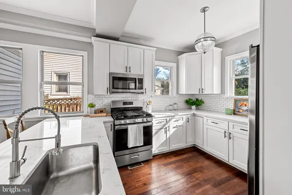 a kitchen with stainless steel appliances granite countertop a stove and white cabinets