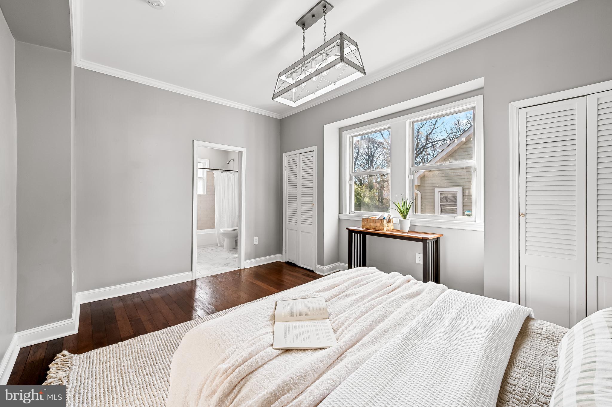 709 Cedarcroft Road Baltimore, MD 21212 - Photo 21 of 38 a bedroom with a bed and a large window with wooden floor