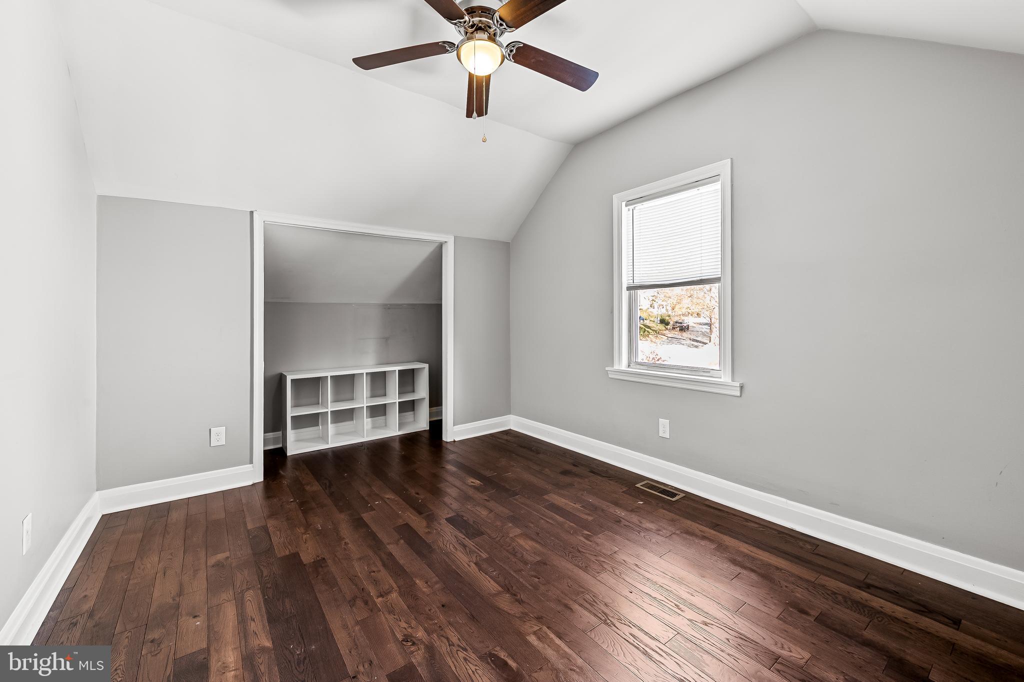 709 Cedarcroft Road Baltimore, MD 21212 - Photo 25 of 38 an empty room with wooden floor chandelier fan and windows