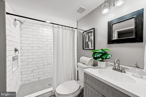 a bathroom with a sink toilet a mirror and shower