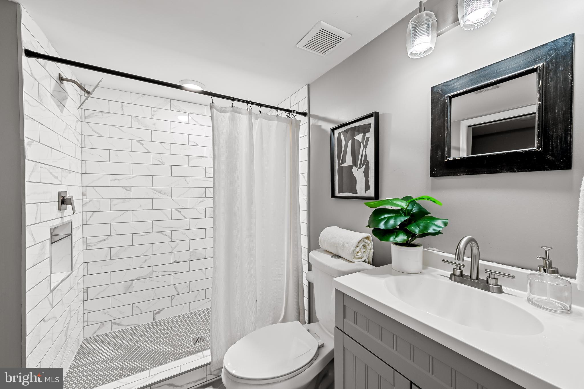 709 Cedarcroft Road Baltimore, MD 21212 - Photo 32 of 38 a bathroom with a sink toilet a mirror and shower