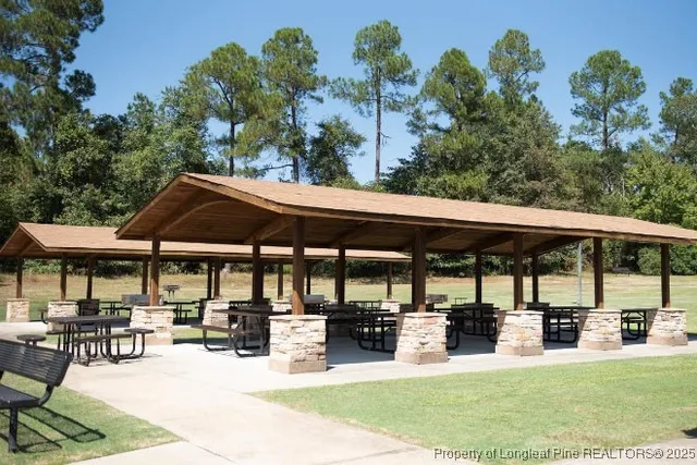 a view of a patio with dining table and chairs under an umbrella with a garden