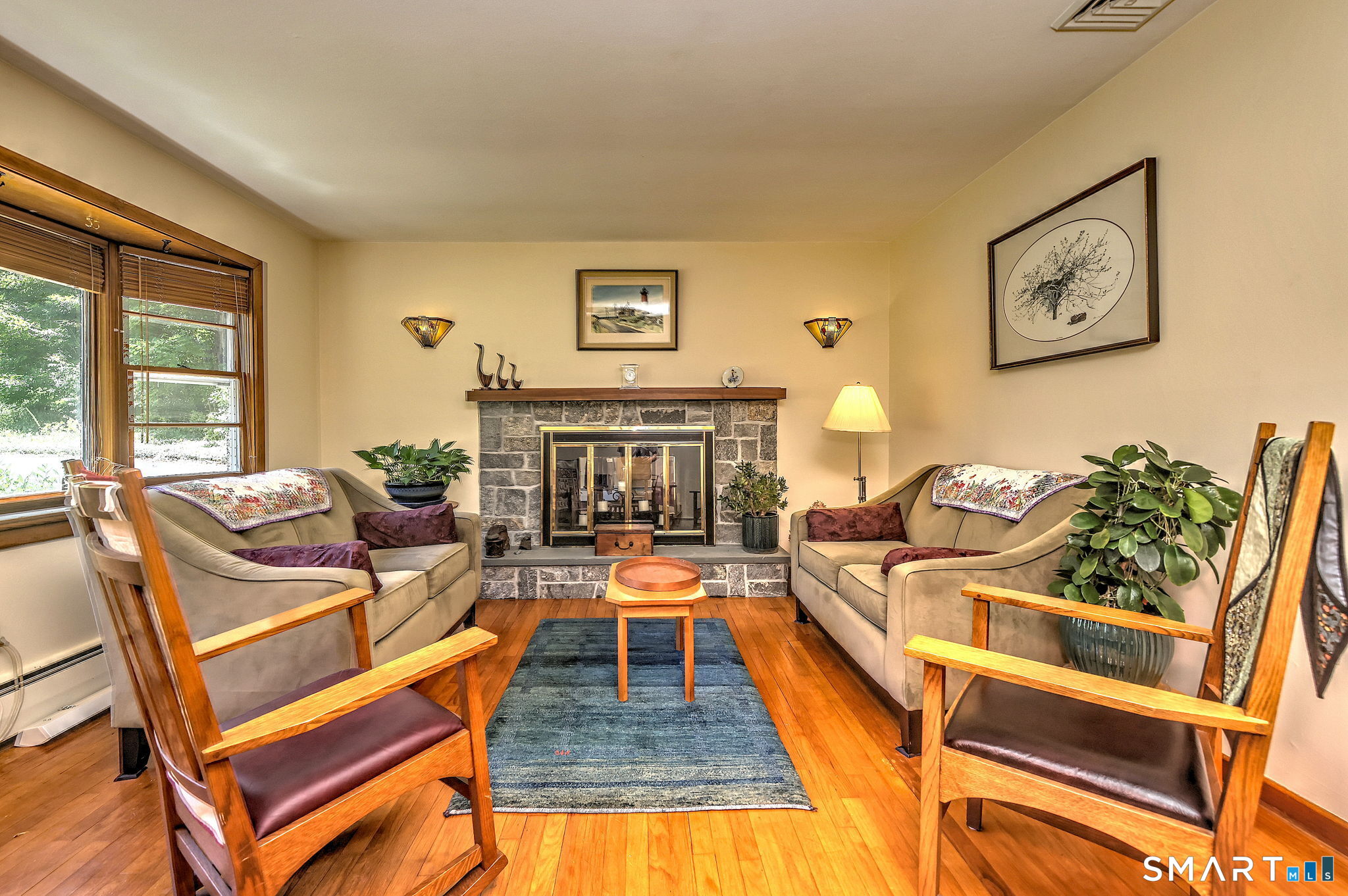 25 Mountain View Road Bethany, CT 06524 - Photo 5 of 27 Cozy living room has large windows overlooking the frontyard that flood the space with natural light, hardwood floors and a pass-through fireplace.